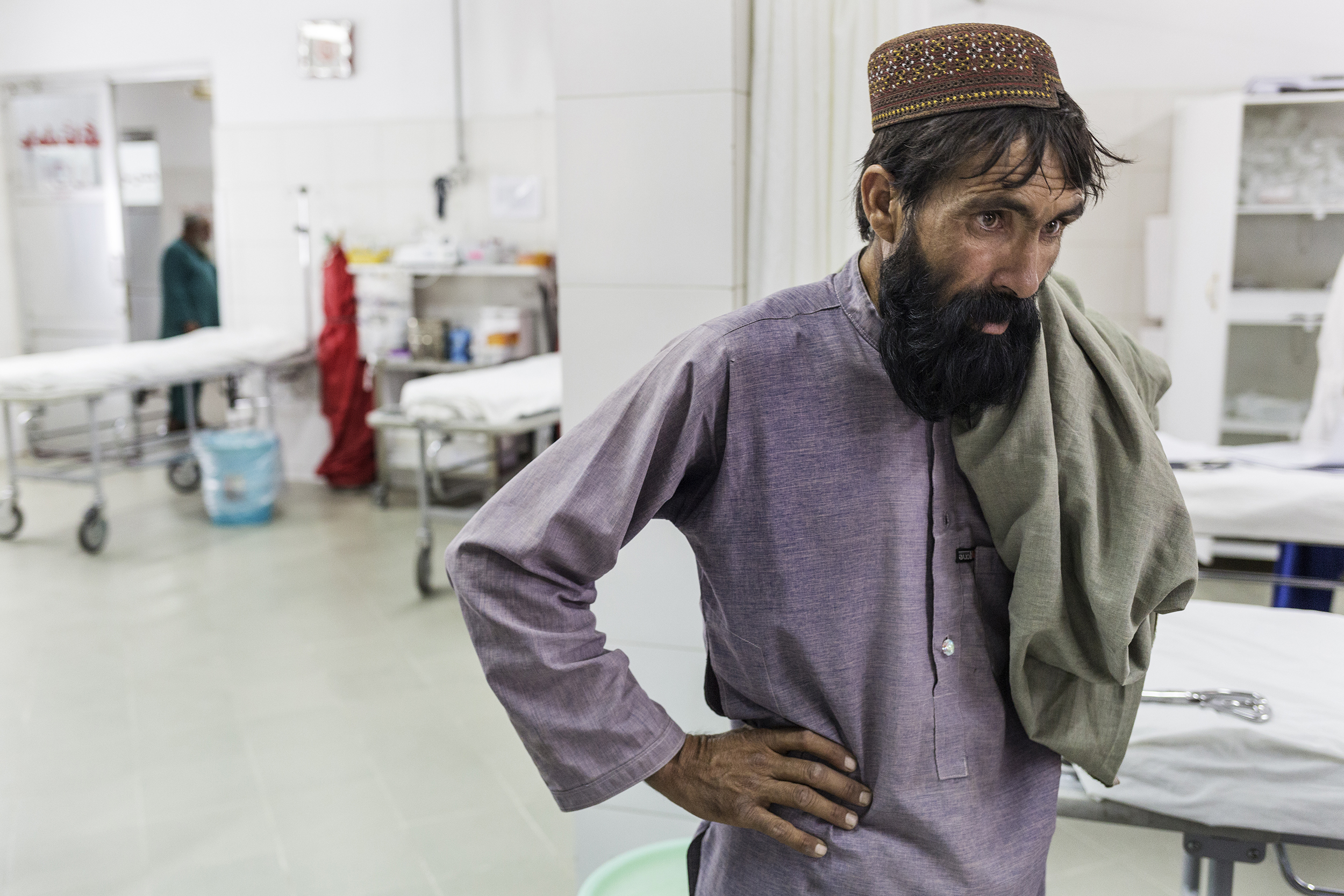 Il padre di Khudai Noor osserva i medici assistere il figlio prima dell'operazione